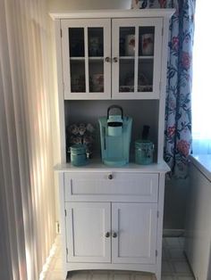 a white cabinet sitting next to a window
