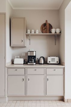 a kitchen with white cupboards and appliances on top of it's counter tops