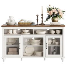 a white cabinet with plates and cups on it, next to a vase filled with flowers