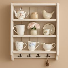 a shelf with cups and saucers on it