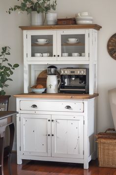 a white hutch with glass front doors and wooden top in a living room area