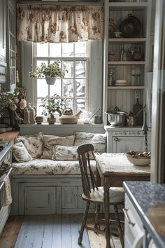 an old fashioned kitchen with white cabinets and wood flooring is furnished with antique furniture