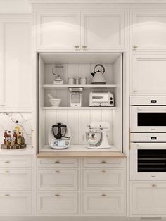 a kitchen with white cabinets and appliances in it